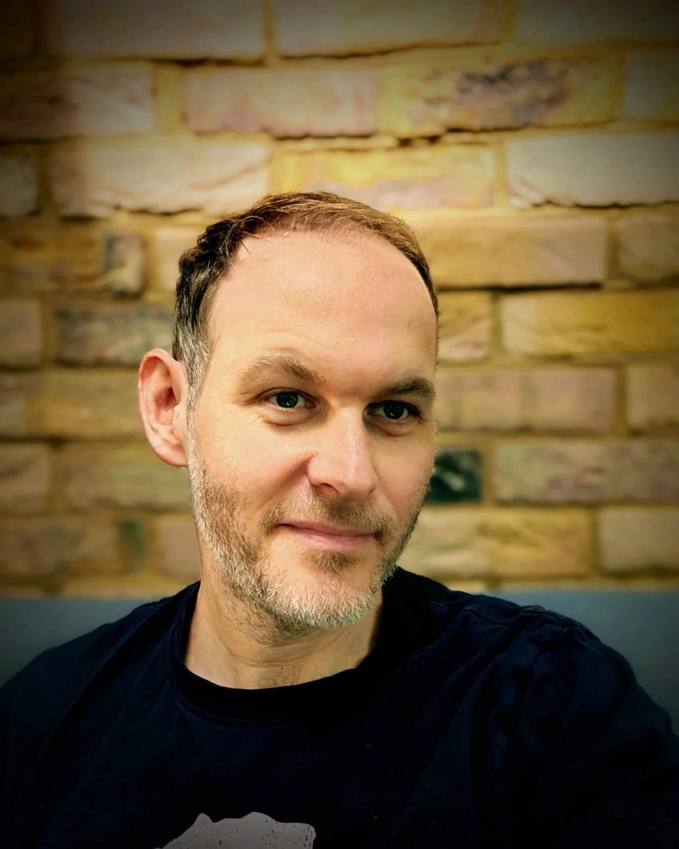 Jayson Robinson, creator of Shellf, photographed against a brick wall in London